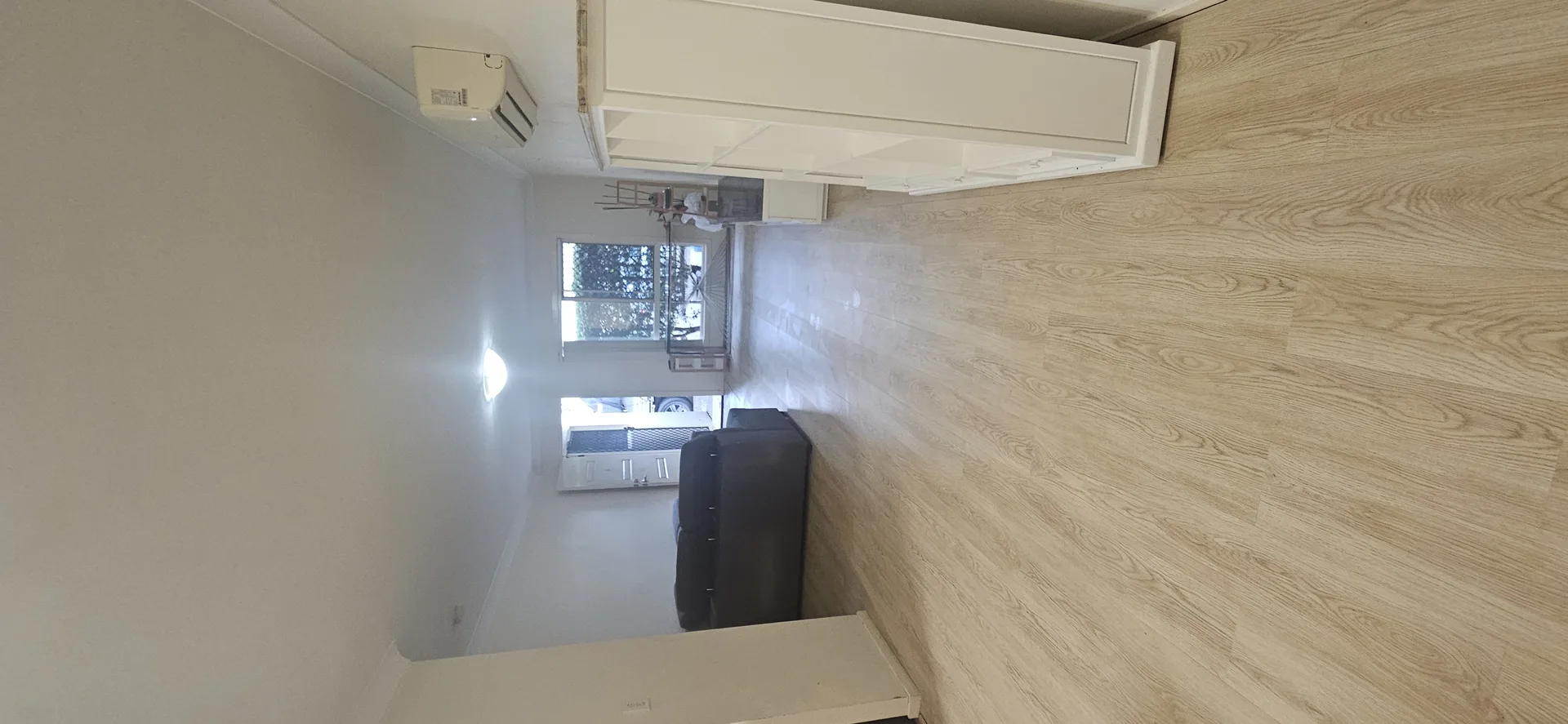 Vinyl plank floor finished — clean honey-oak timber-look planks running through living area on Gold Coast