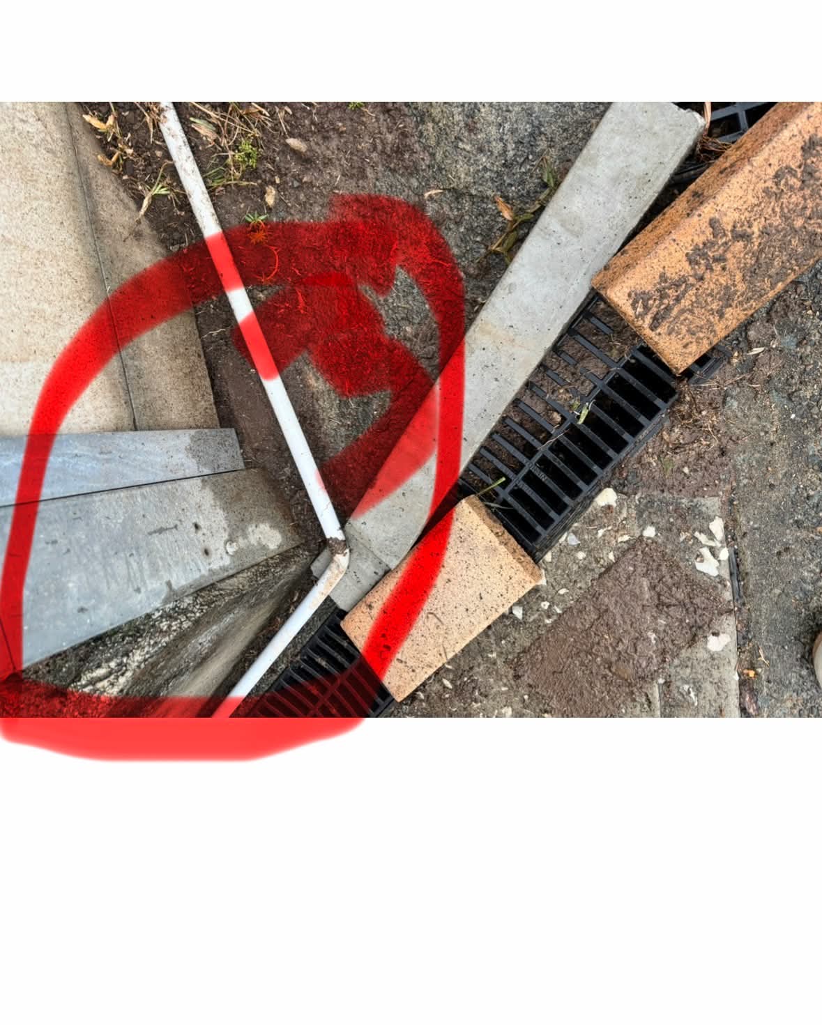Poorly installed drainage pipe junction running into a surface drain