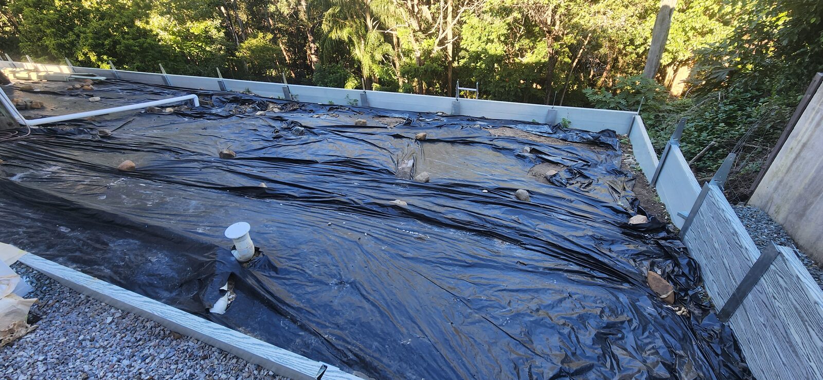 The levelled pad area lined with black plastic inside the new retaining walls at Highland Park