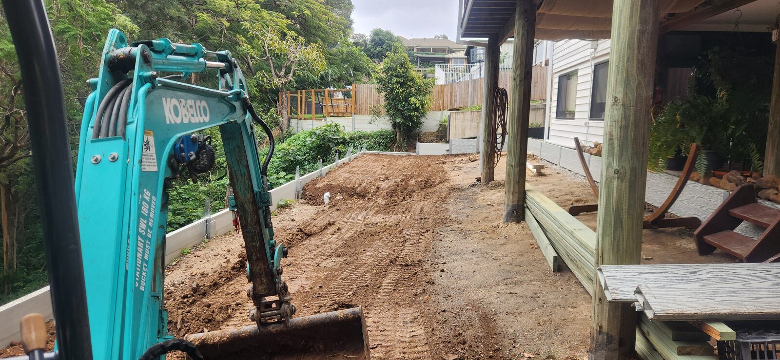 The 1.7-tonne excavator levelling the ground in the tight space alongside the house at Highland Park